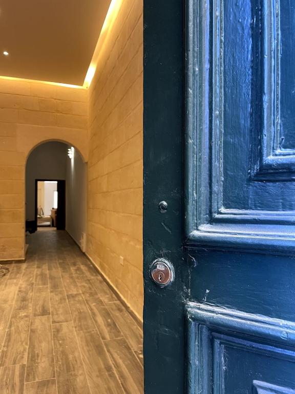 a blue door in a room with a hallway at The Old Mint House sleeps 15 in Valletta