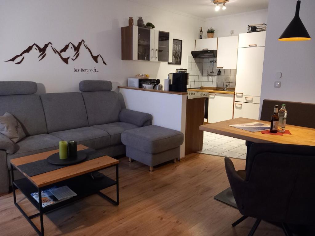 een woonkamer met een bank en een tafel en een keuken bij Hortensia -213- in Mittenwald