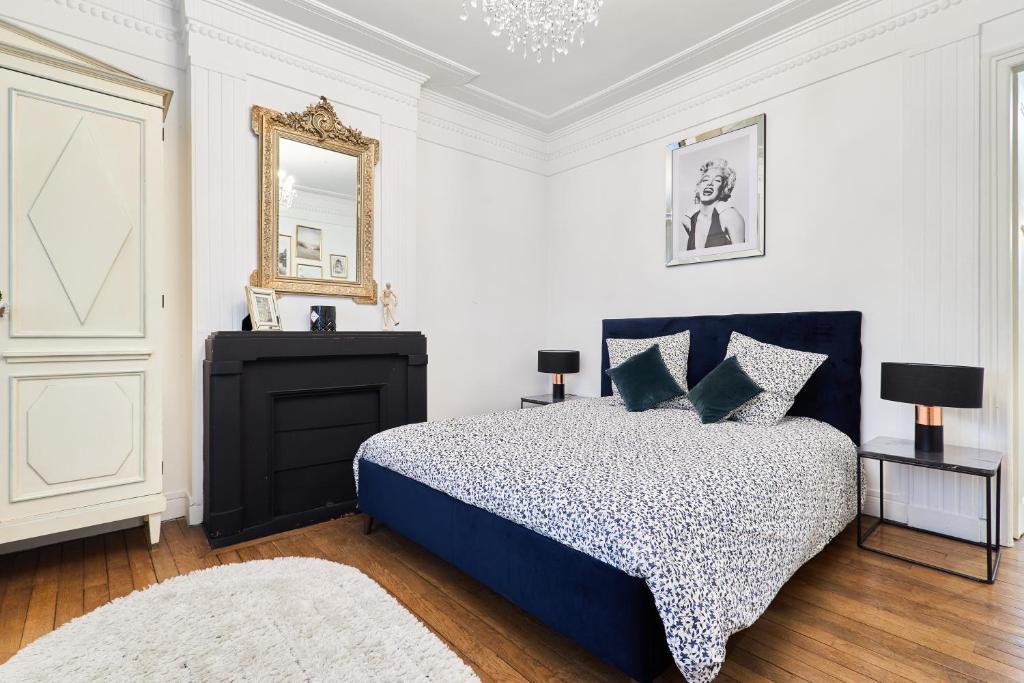 une chambre avec un lit bleu et un miroir dans l'établissement Suite Vesle, à Reims