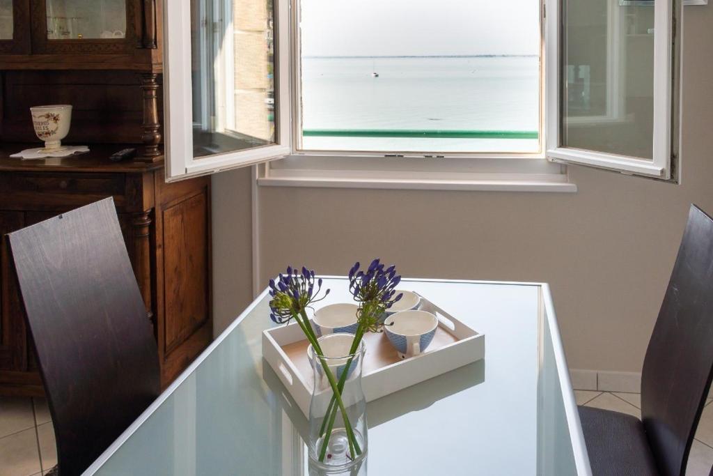een glazen vaas met paarse bloemen op een tafel bij Les Reflets de la Houle in Cancale