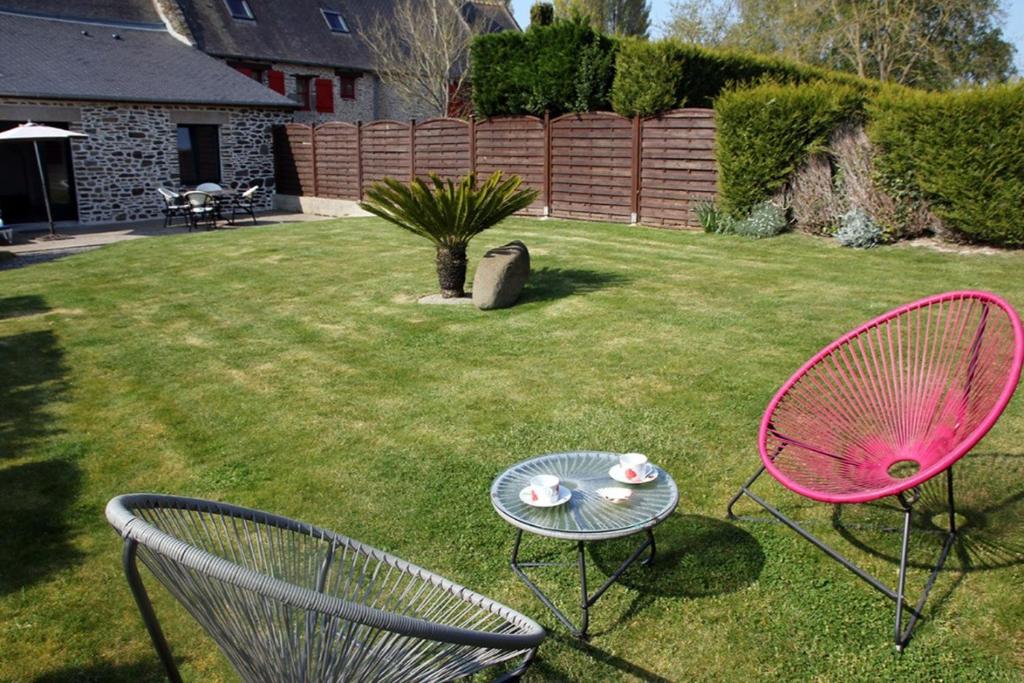 two chairs and a table in a yard at Gîte Radegonde in Saint-Méloir-des-Ondes