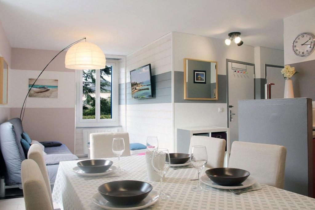 Un comedor con una mesa con cuencos encima. en Comme à la maison, en Cancale