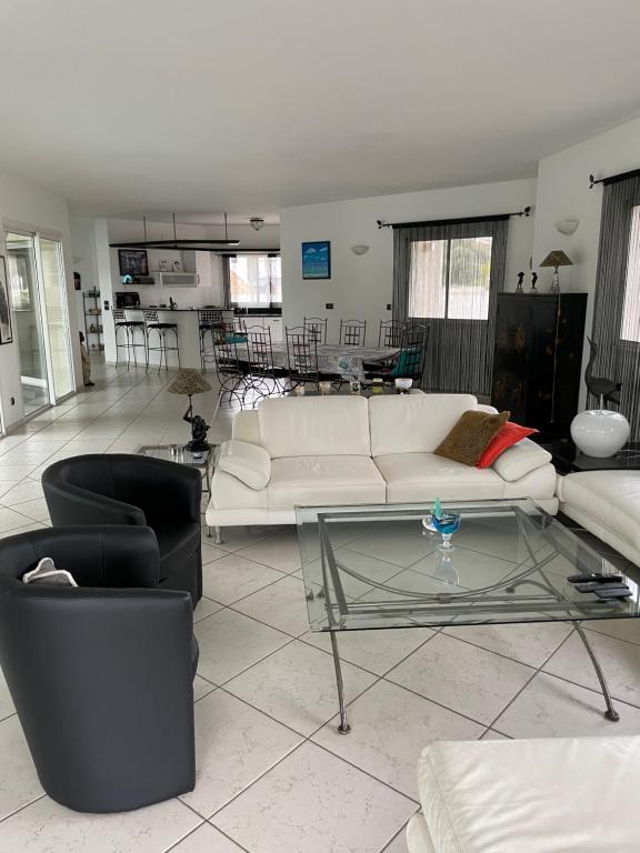 un salon avec un canapé blanc et une table en verre dans l'établissement Ghiso, à Ghisonaccia