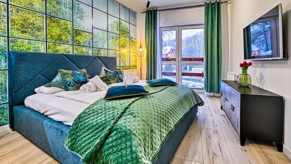 a bedroom with a large bed and a large window at Holiday Mountain Residence, Sun & Snow in Świeradów-Zdrój
