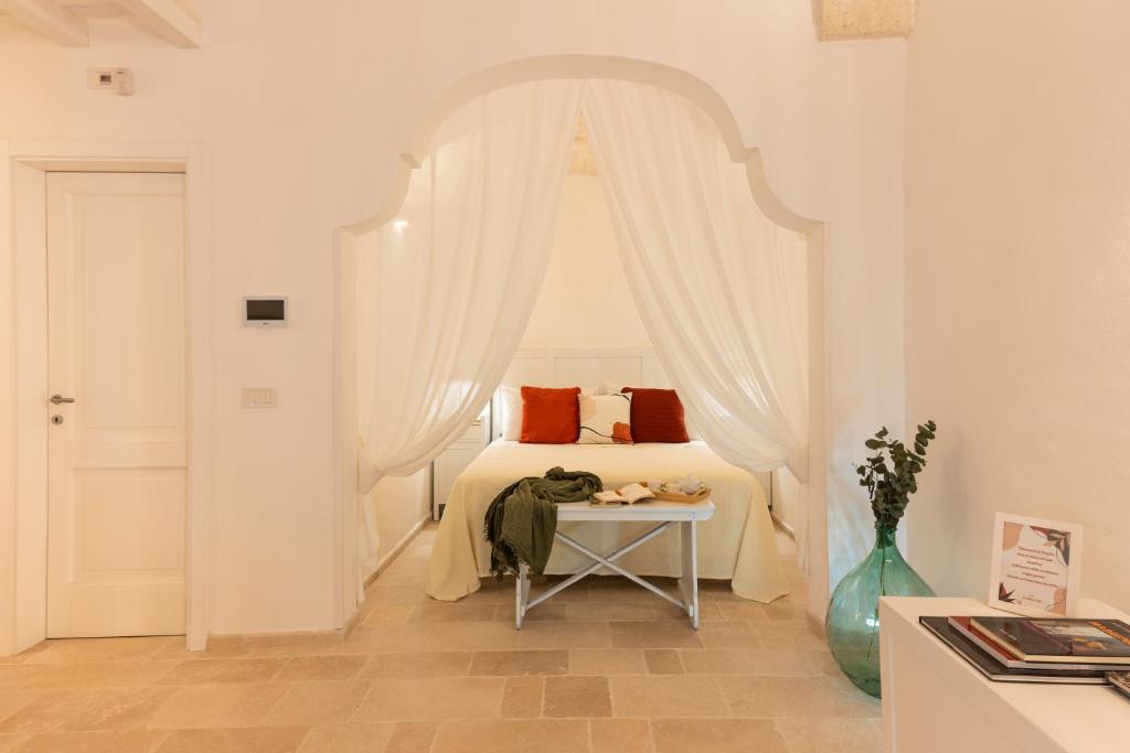 ein Schlafzimmer mit einem Bett mit weißem Baldachin in der Unterkunft Le Antiche Volte in Fasano