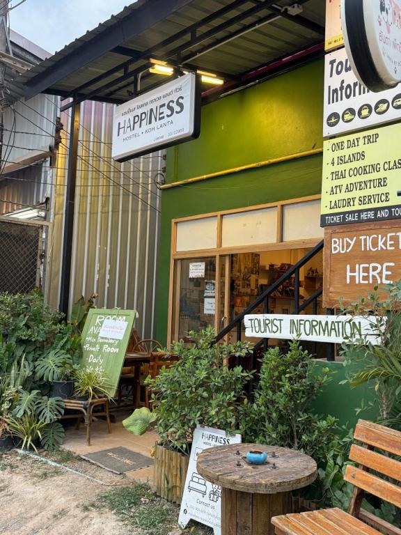 a store with a table in front of a building at Happiness Hostel Private room in Phra Ae beach