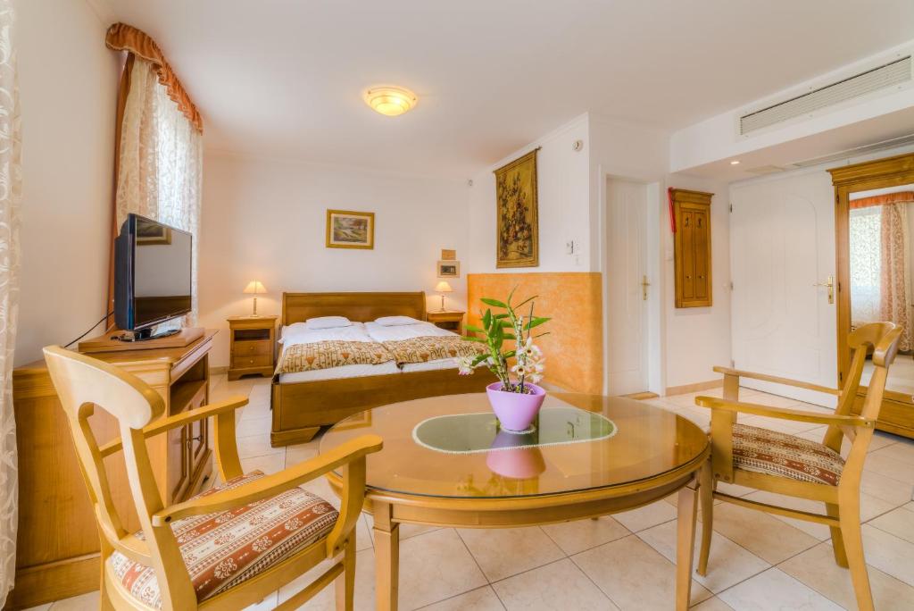 塞格德的住宿－卡塔酒店，客厅配有桌子和床。