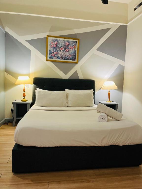a bedroom with a large white bed with two lamps at Millennium Suites At Berjaya Times Square KL in Kuala Lumpur
