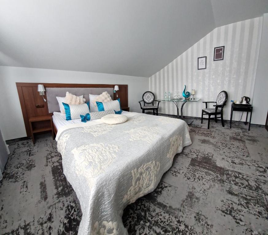 a bedroom with a large bed with blue pillows at Cynamon in Nowy Sącz