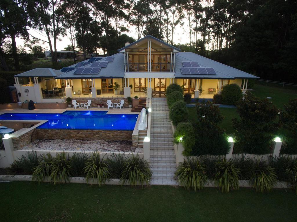 a house with a swimming pool in front of it at The Ridge Retreat at Mollymook in Mollymook