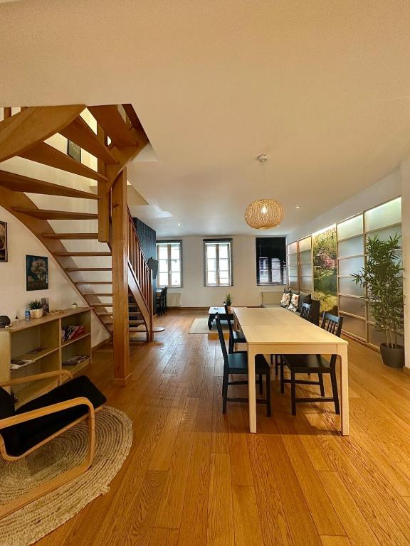 un salon avec une table et un escalier dans l'établissement Le Soleil-Levant centre-ville, à Chalon-sur-Saône
