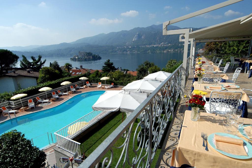 a balcony with a pool and a view of the water at Hotel La Bussola in Orta San Giulio