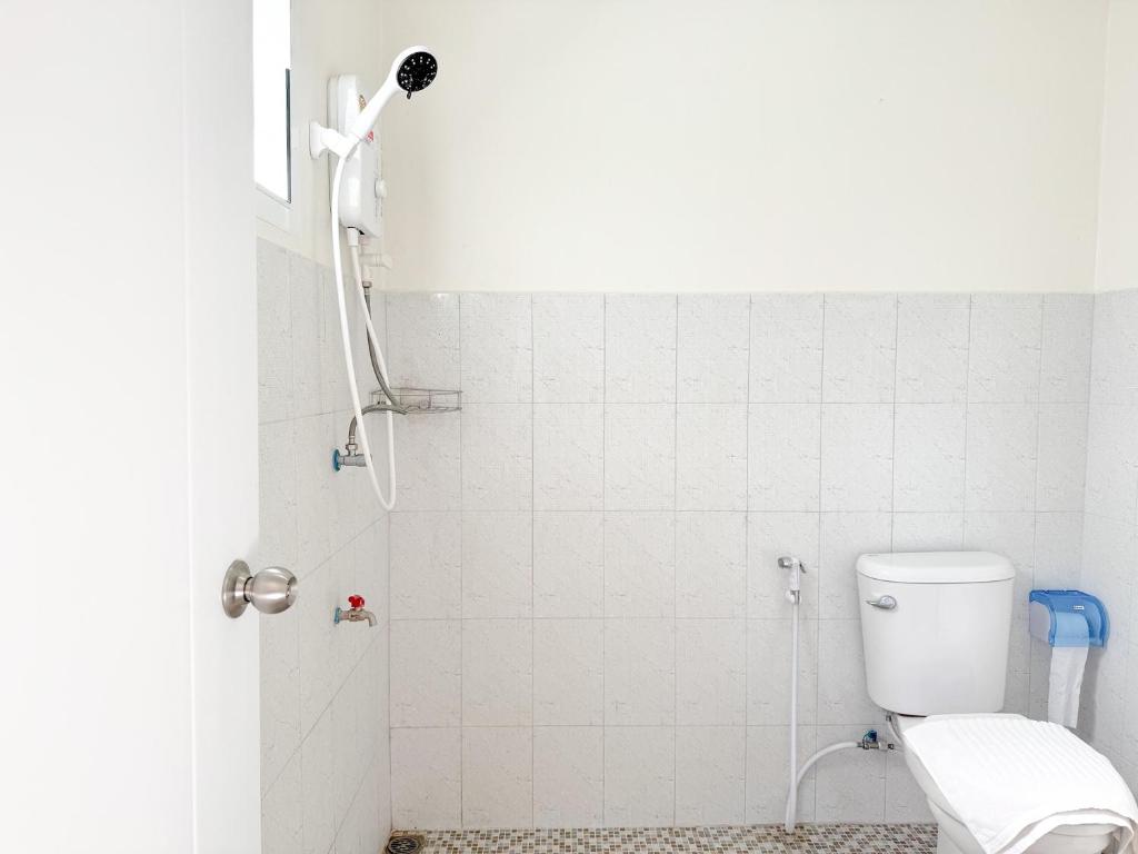 a bathroom with a shower with a toilet at Jira Hotel in Lampang