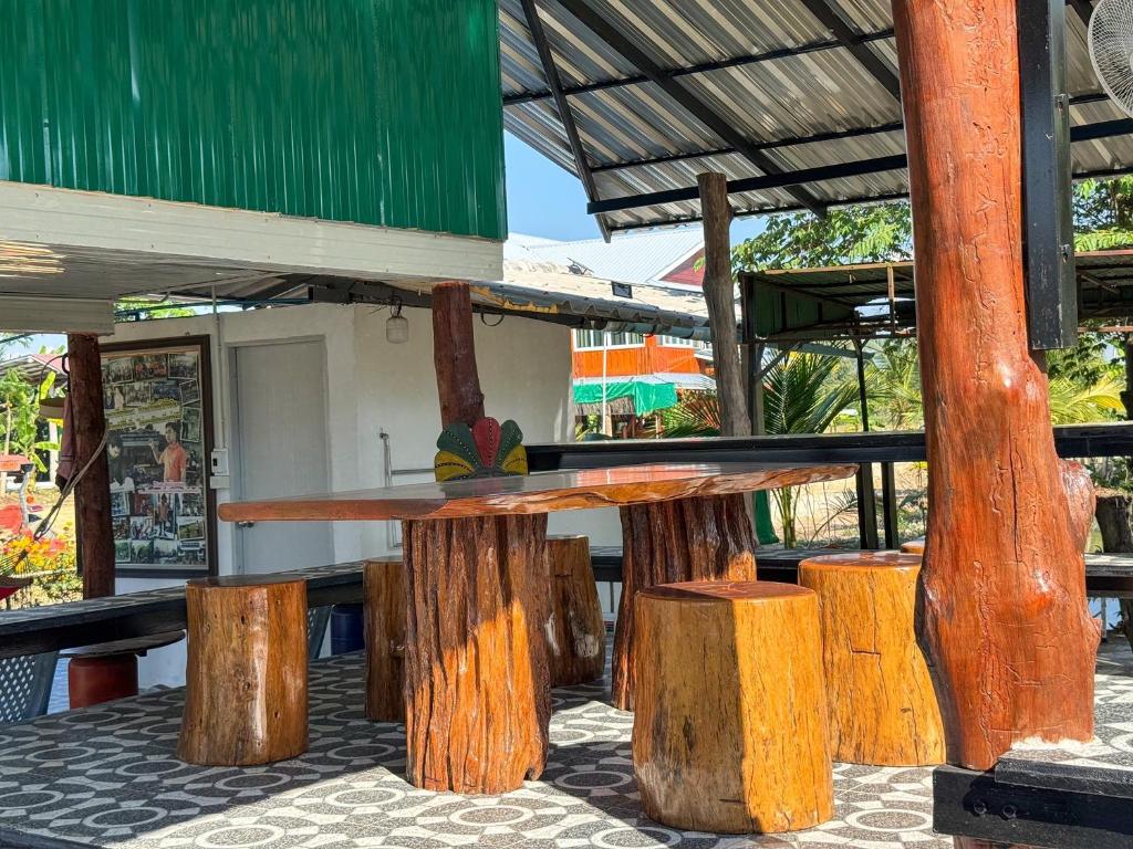 a wooden table and some wooden stumps at Jira Hotel in Lampang
