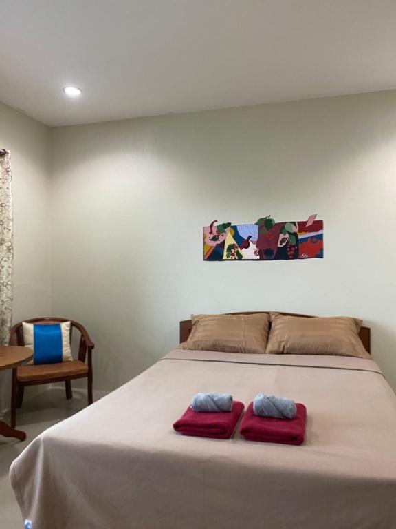 a bedroom with a bed with two red pillows on it at Jack's house Thara in Krabi