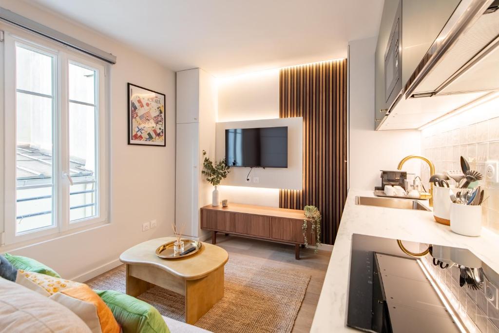 un salon avec un canapé et une télévision dans l'établissement Stunning Tiny Studio - 5 min to Eiffel Tower - Sleeps 2P, à Paris