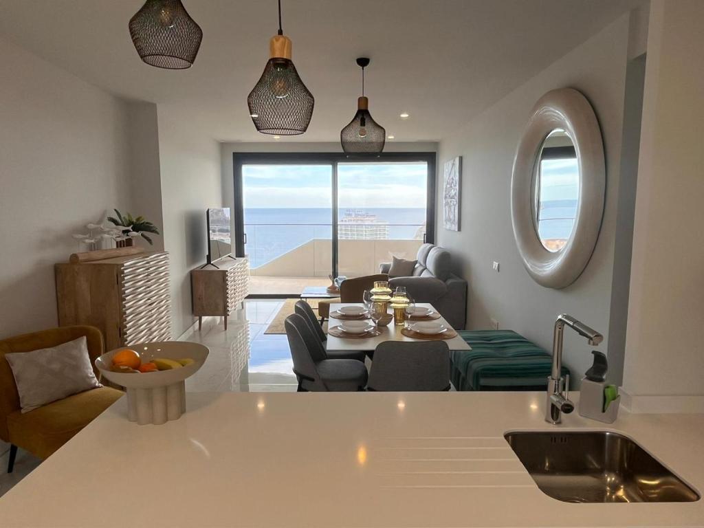 a kitchen and living room with a view of the ocean at Benidorm Beach apartment - Costa Blanca in Benidorm