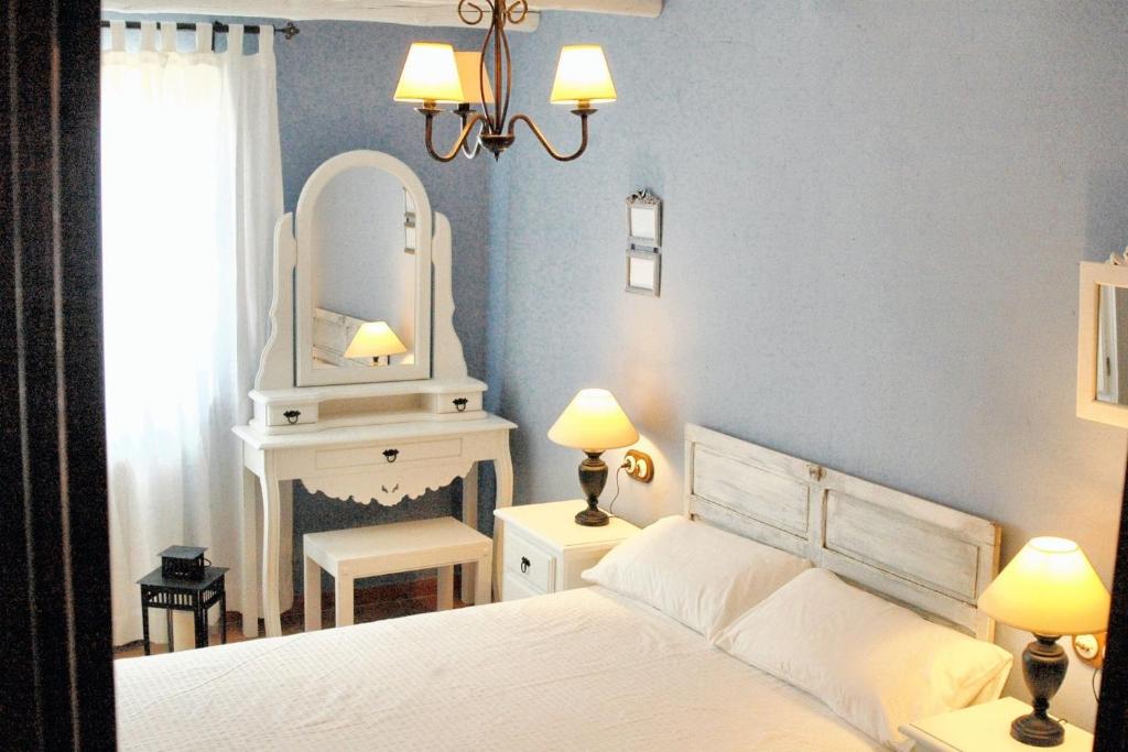 ein Schlafzimmer mit einem weißen Bett und einem Spiegel in der Unterkunft Welcoming House in Alcaracejos with Shared Pool in Alcaracejos