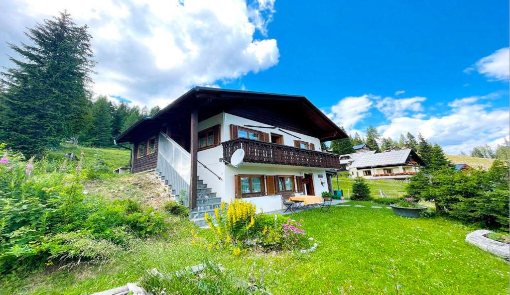 a house on a hill with a green yard at Chalet Heinrich Ski in & Ski out - Apartment Bergblick in Sonnenalpe Nassfeld