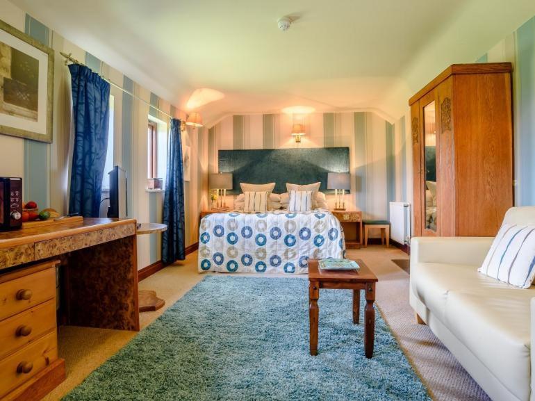 a large bedroom with a bed and a couch at Stables Studio in Bedford