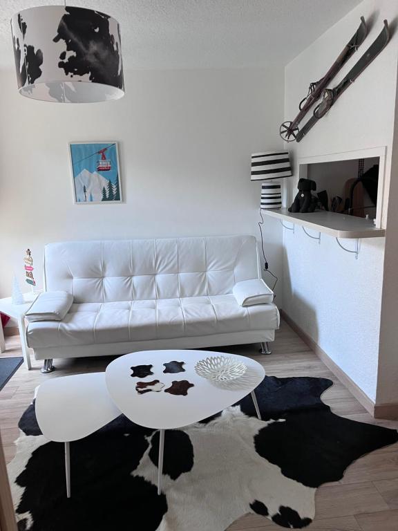 un salon avec un canapé blanc et une table dans l'établissement T3 cosy et calme, Balcon, Parking, cœur du village, à Saint-Lary-Soulan