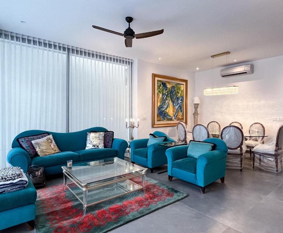 a living room with blue couches and chairs at Villa Mamakami - Private Luxury Rooms in Canggu in Canggu