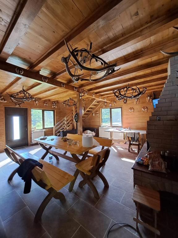 a dining room with a table and chairs and a chandelier at Cabana cu trofee in Schitu-Tarcău