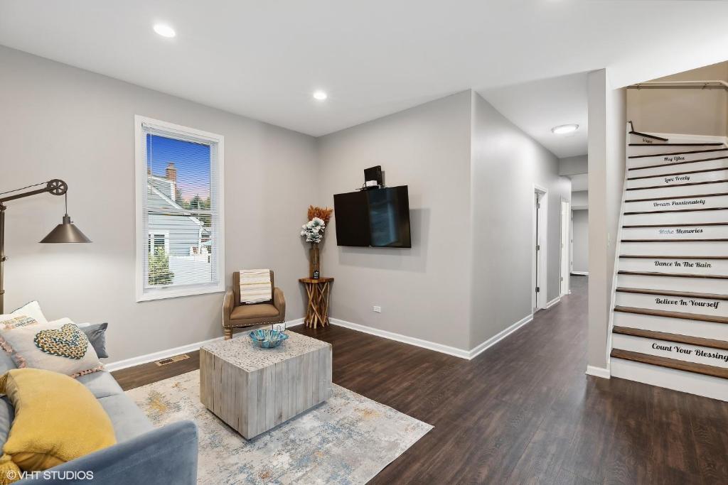 a living room with a couch and a tv at Modern Retreat, Double lot with Pergola, Fire pit, Game room, 5 min to Brookfield Zoo in Brookfield