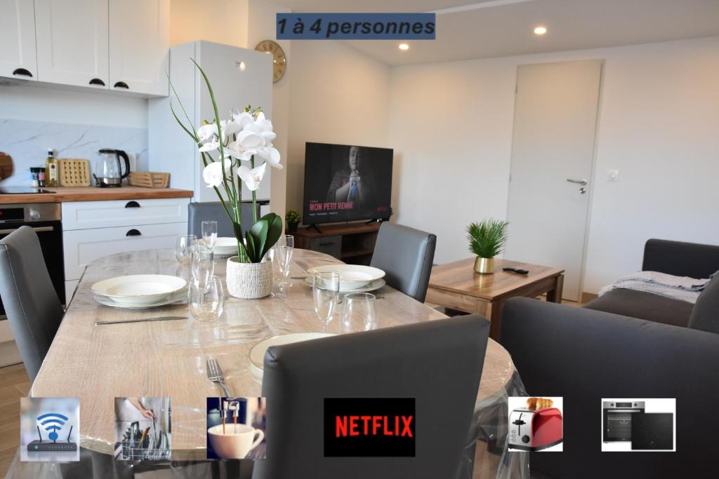 a kitchen and living room with a table and chairs at Refuge du Château avec terrace in Manom