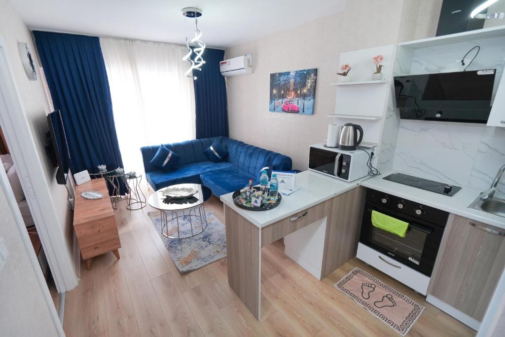 eine kleine Küche und ein Wohnzimmer mit einem blauen Sofa in der Unterkunft Classic Suite TS33 in Esenyurt