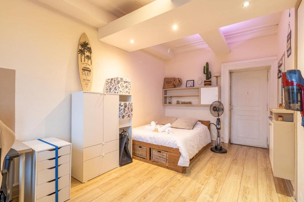 - une chambre avec un lit et un réfrigérateur dans l'établissement Cozy T1 with Wifi in the heart of Toulouse, à Toulouse