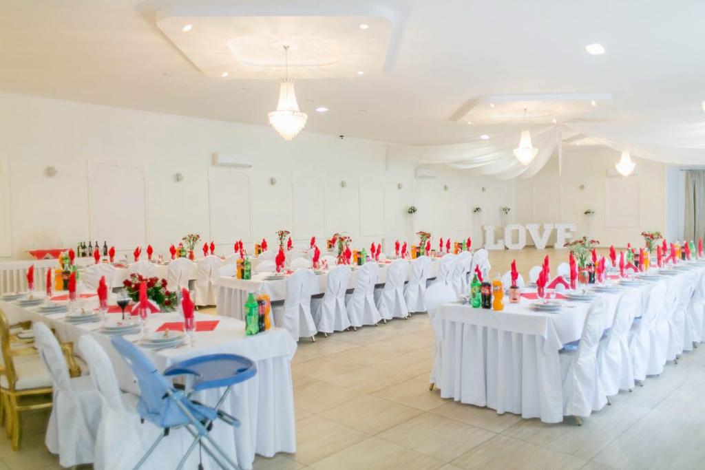 a room with white tables and chairs with red figurines on them at Marysienka in Bisztynek