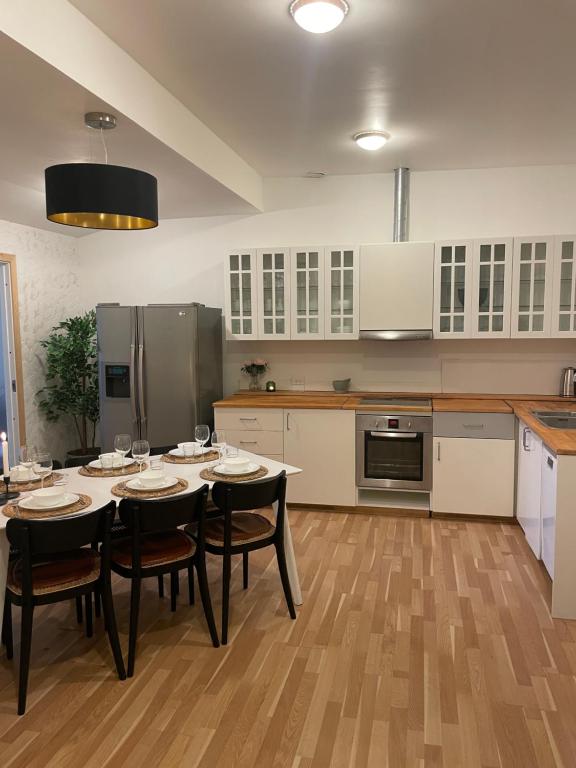 a kitchen with a table with chairs and a refrigerator at Country flat in beautiful nature in Gadstrup