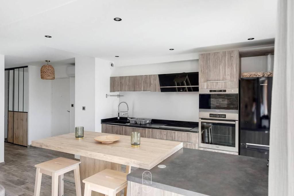 Il comprend une cuisine avec une table et des chaises en bois. dans l'établissement Hyères Centre-Les Floralies T3/Clim/Garage/balcon by HC, à Hyères