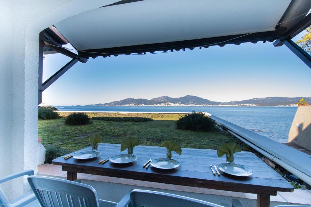 - une table avec des chaises et une vue sur l'eau dans l'établissement Studio pieds dans l'eau, à Grosseto-Prugna