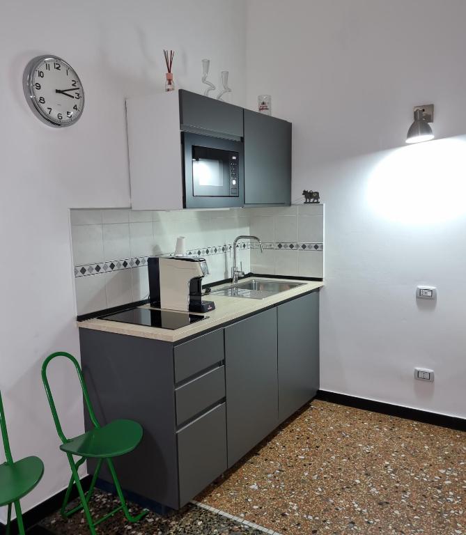 a kitchen with a sink and a clock on the wall at Affittacamere House LeoMar di Sara in Genoa