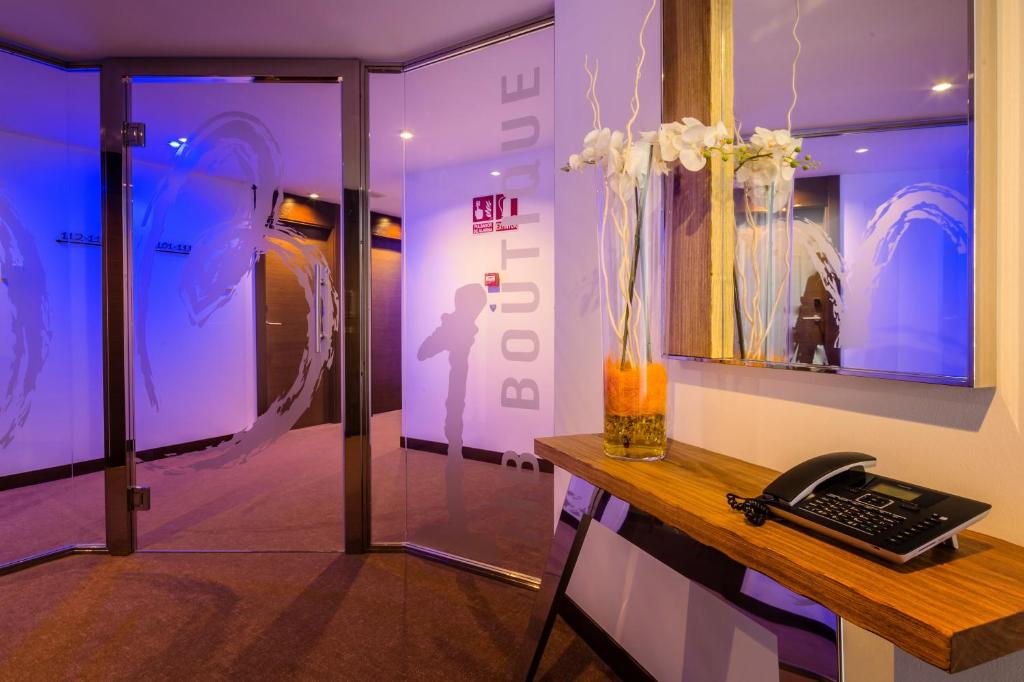 a room with a desk with a phone and a window at MB Boutique Hotel - Adults Recommended in Nerja