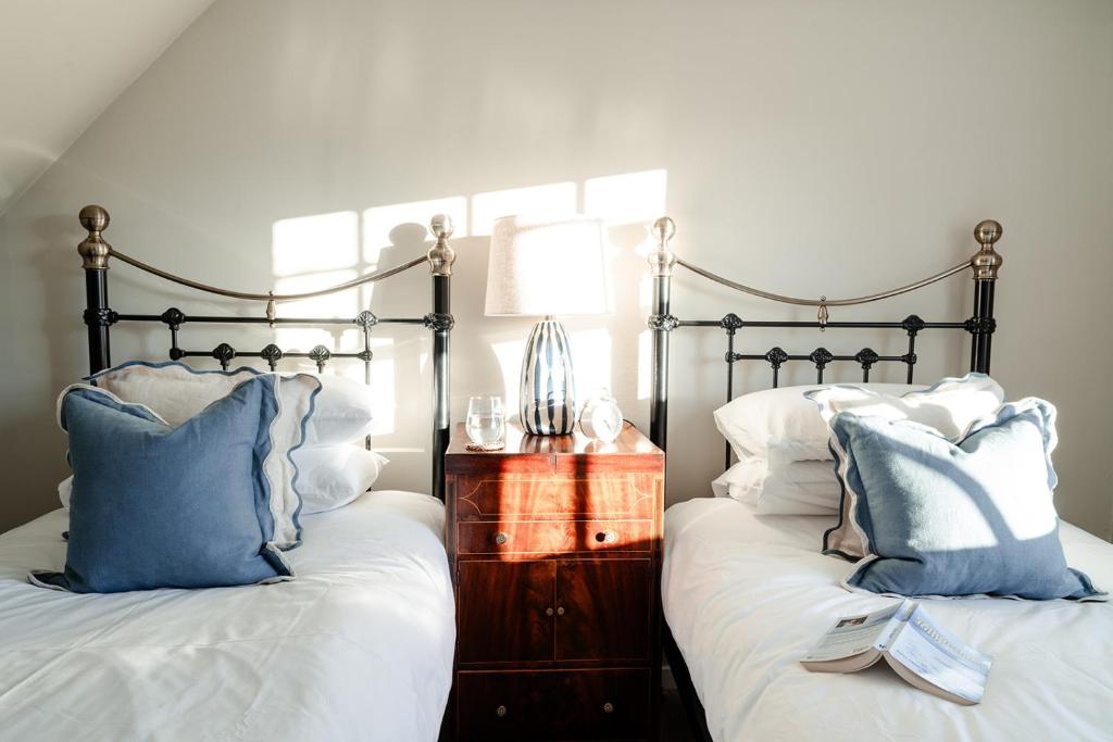 ein Schlafzimmer mit zwei Betten mit blauen und weißen Kissen in der Unterkunft Park Cottage - Seasgair Lodges in Kingussie