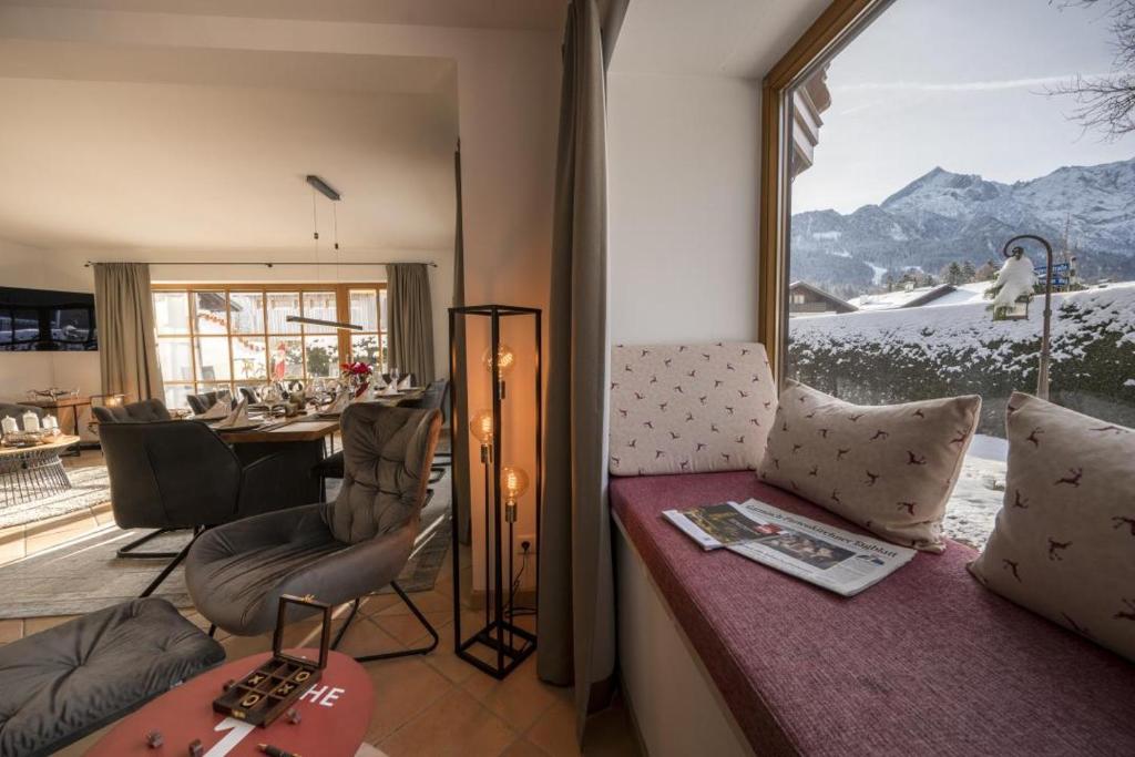 a living room with a large window with a view of the mountains at Ferienhaus Die 14 mit Infrarotkabine in Garmisch-Partenkirchen