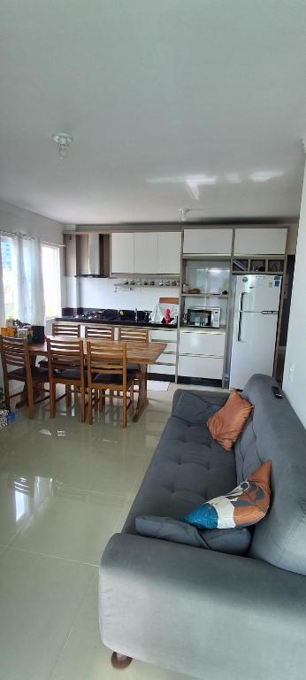 纳韦甘蒂斯Suíte 50 metros da praia, 10 km Beto Carrero e BC, local compartilhado的带沙发的客厅和餐厅