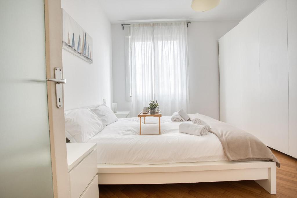een witte slaapkamer met een wit bed en een raam bij Easylife - Milano - Morosini 32 - Porta Romana in Milaan