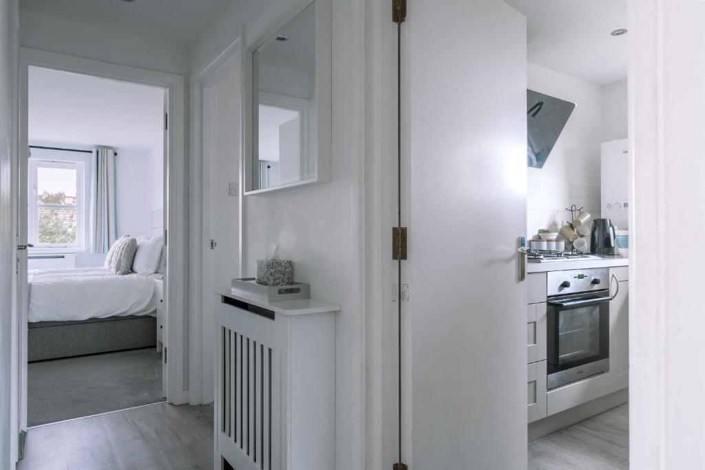 a white kitchen with a sink and a stove at HighTide - 2 bed with parking, balcony & sea view. in Swanage