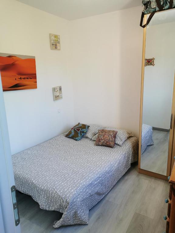 une chambre avec un lit et un miroir dans l'établissement Appartement au coeur des vignes region pic st Loup, à Claret
