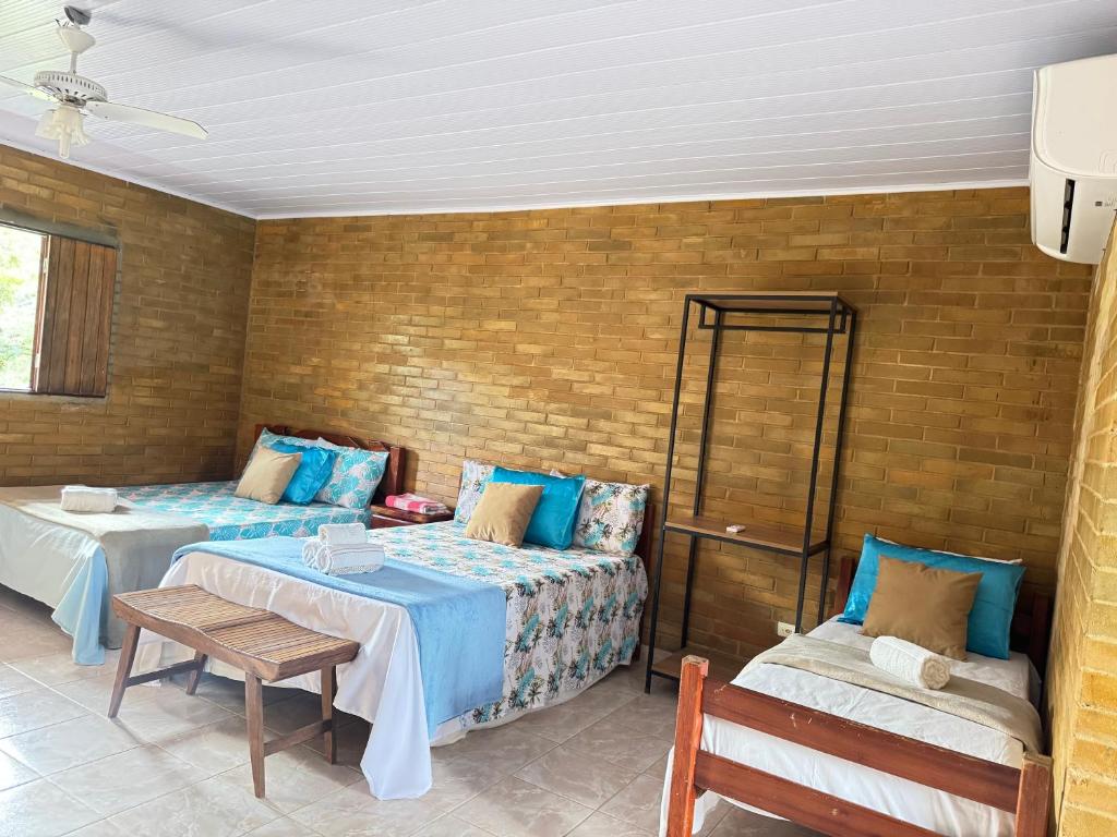 a room with two beds and a table and a chair at Eco Flat 321 Condomínio Pedra do Rodeadouro in Bonito