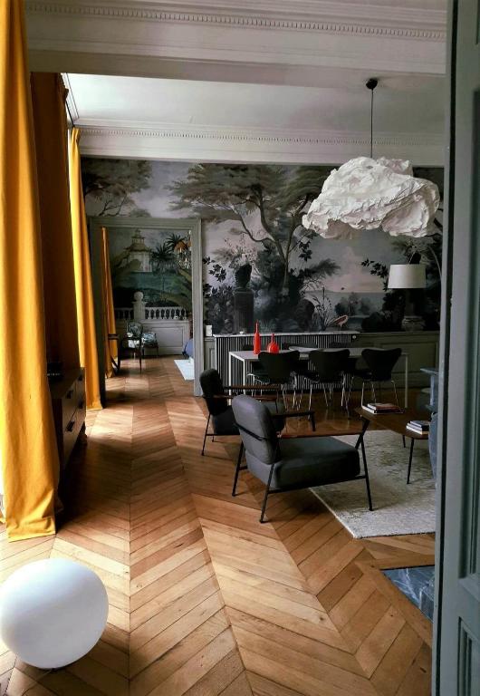 - une salle à manger avec une table, des chaises et un mur dans l'établissement Apartment Carrelet de Loisy, à Dijon