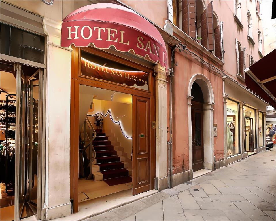 una tienda frente con un cartel hotelero en una calle en Hotel San Luca Venezia, en Venecia