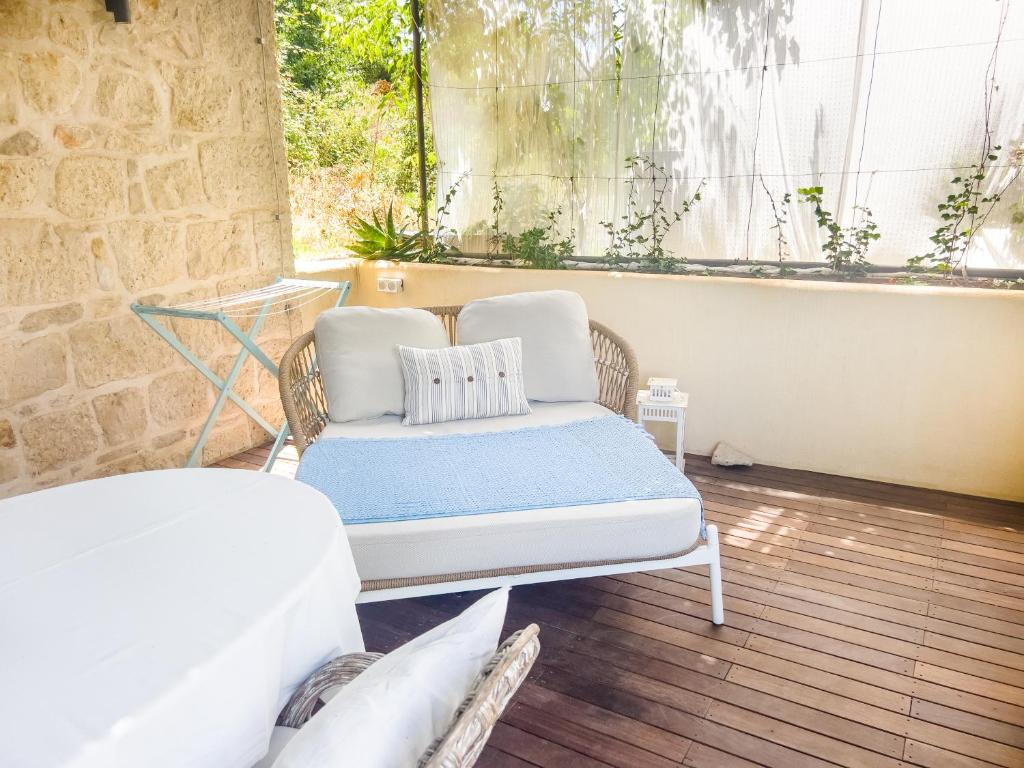 a bed and a couch in a room with a window at ECO Aparthotel The Dreamers's Club in Lumbarda