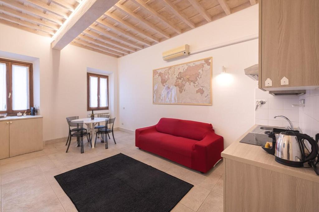Una sala de estar con un sofá rojo y una mesa. en Villa Strozzi Travel Apartment, en Florencia