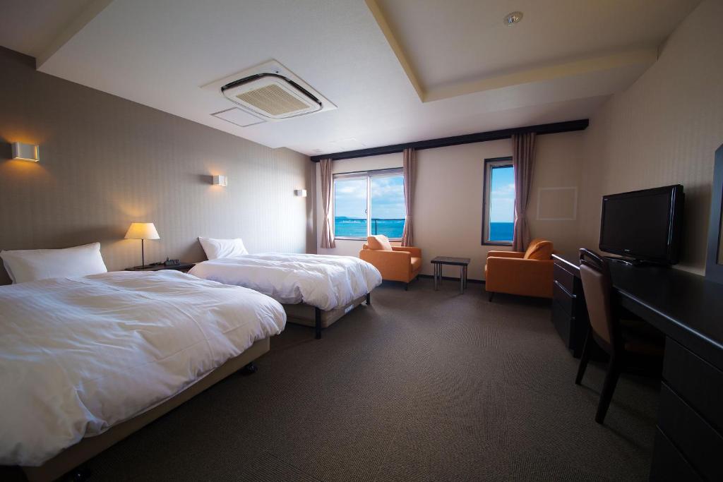 Postel nebo postele na pokoji v ubytování Seaside Hotel Taimaru Kaigetsu