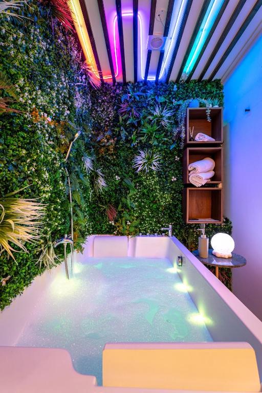 Cette chambre dispose d'un mur vert et d'une baignoire. dans l'établissement Cozy Jacuzzi Bordeaux Chartrons, à Bordeaux